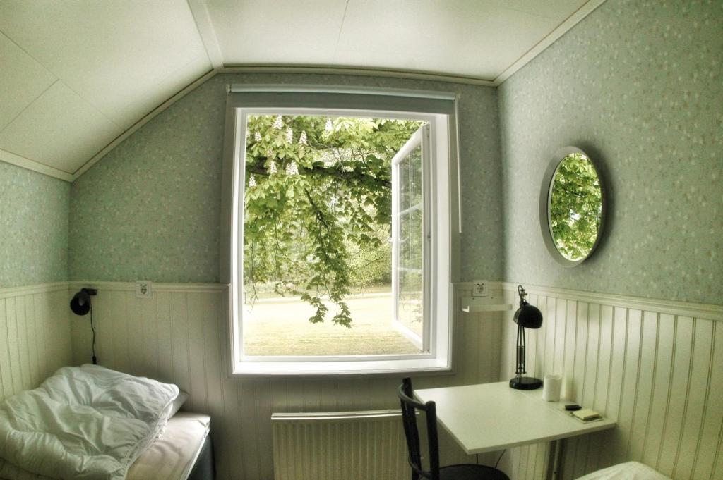 Lundsbrunn的住宿－Lundsbrunn B&B，客房设有窗户、书桌和桌子。