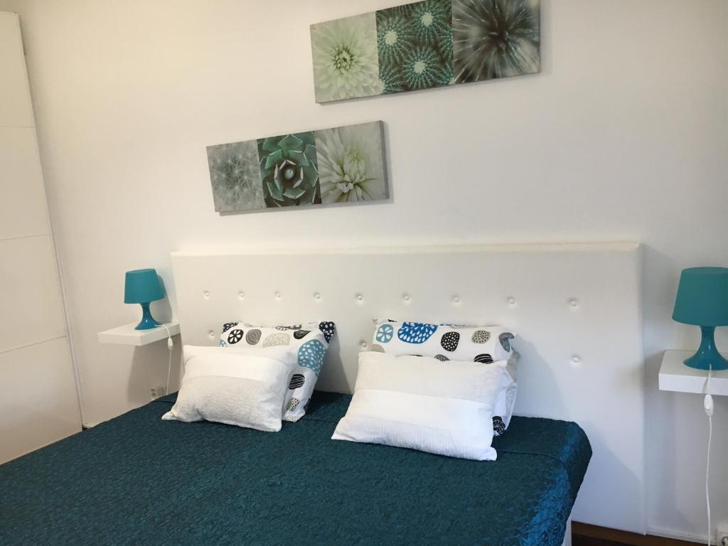 een slaapkamer met een bed met witte en blauwe kussens bij Soul Surfer in Peniche