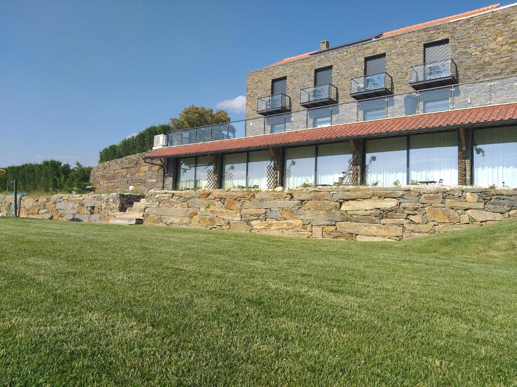 un edificio con un muro di pietra e un prato di Quinta da Corujeira a Vila Real