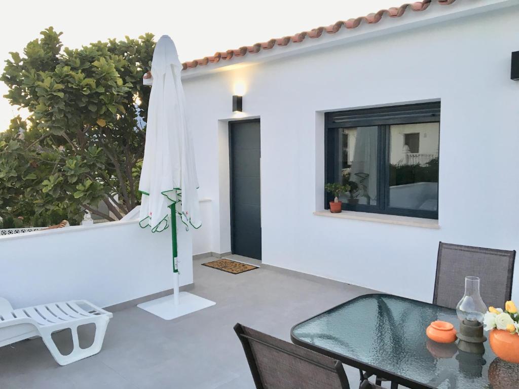 a dining room with a glass table and a umbrella at Mediterranea Suite Apartment in Albir