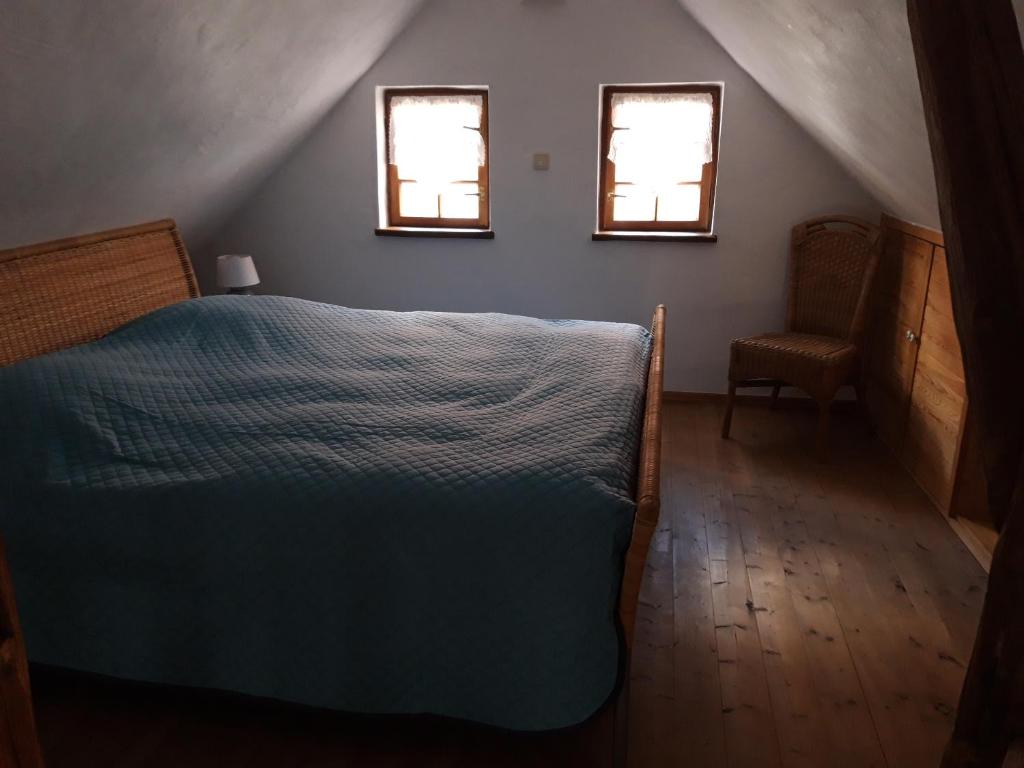 ein Schlafzimmer mit einem Bett und zwei Fenstern in der Unterkunft Diebacher Hof in Büdingen