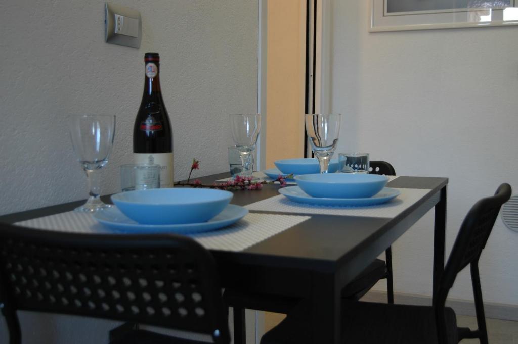 un tavolo con ciotole e bicchieri e una bottiglia di vino di Casa Ninou a Domaso