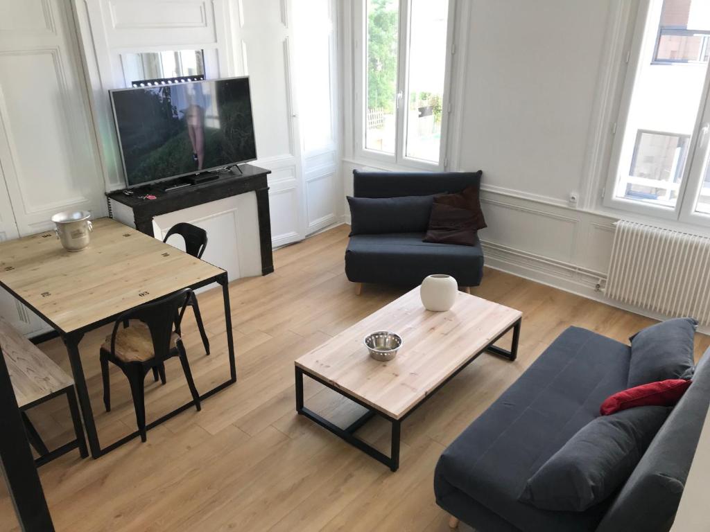 a living room with a couch and a table at Le secret de Léa in Rouen