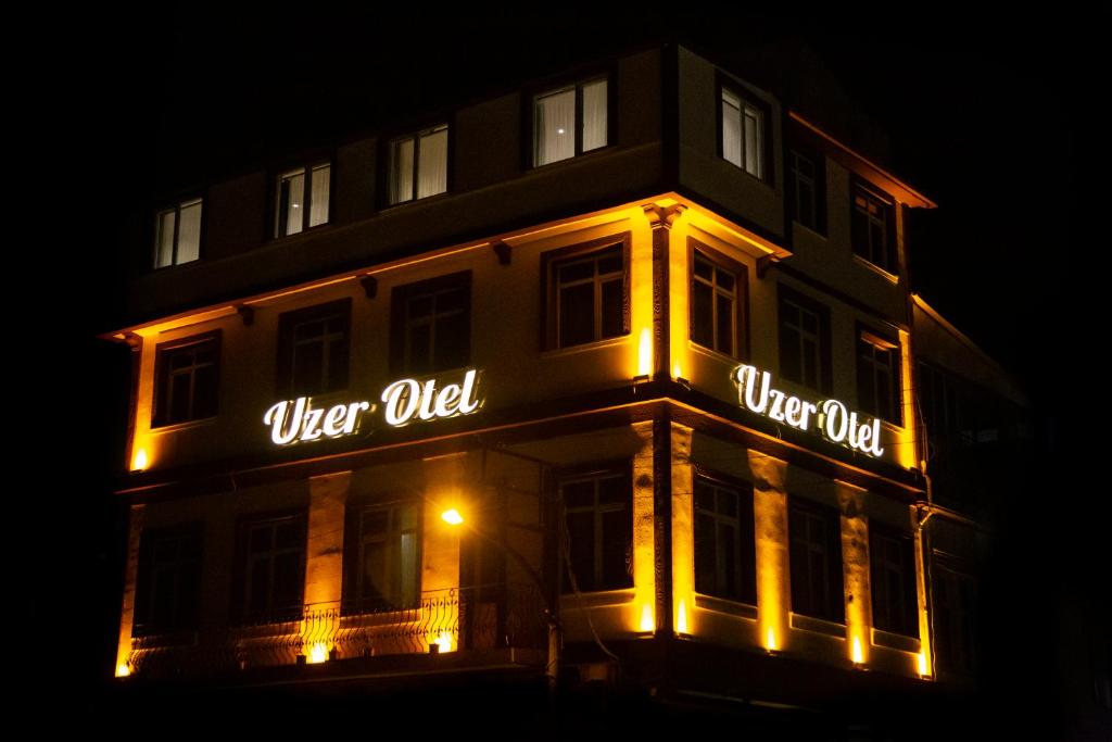 a building with lit up signs on it at night at UZER OTEL in Trabzon