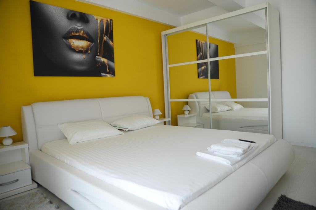 a bedroom with a white bed and a mirror at Milan in Mamaia Nord