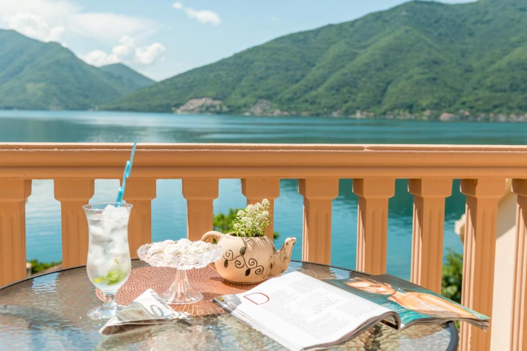 una mesa en un balcón con vistas al agua en Apartments Stella del Mare, en Risan