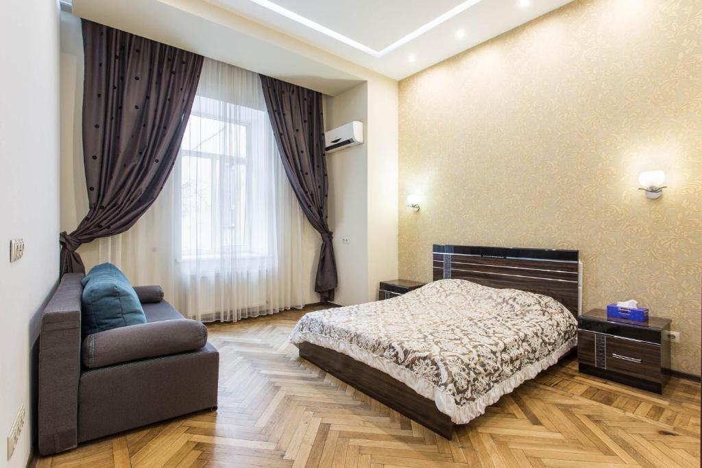 um quarto com uma cama, uma cadeira e uma lareira em Odessa 3bedroom Deribas apartment em Odessa