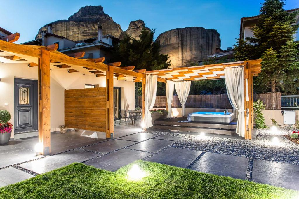 a patio with a wooden pergola and a bed at Meteora boutique villa E in Kalabaka