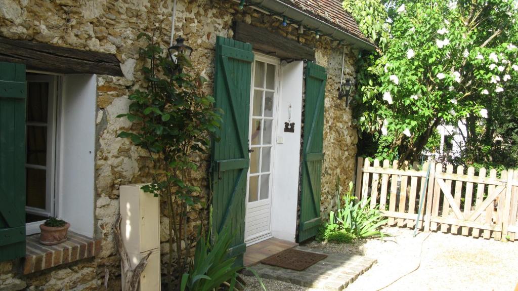 una entrada a una casa de piedra con una puerta verde en Florette, en Gourville