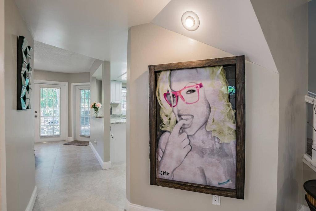 a painting of a woman with red glasses on a wall at Luxury Holistic Oasis by Bayshore/Hyde Park/SoHo in Tampa
