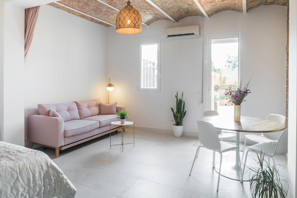 a white living room with a couch and a table at Magic Apartment with Private Terrace in Barcelona