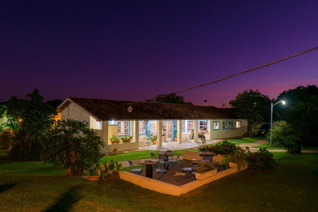 a house with a patio at night at Hotel Alto da Boa Vista in Analândia