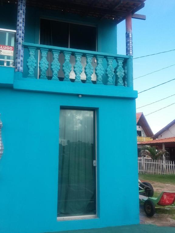 een blauw huis met een balkon bij Kitnet no Farol Velho in Salinópolis