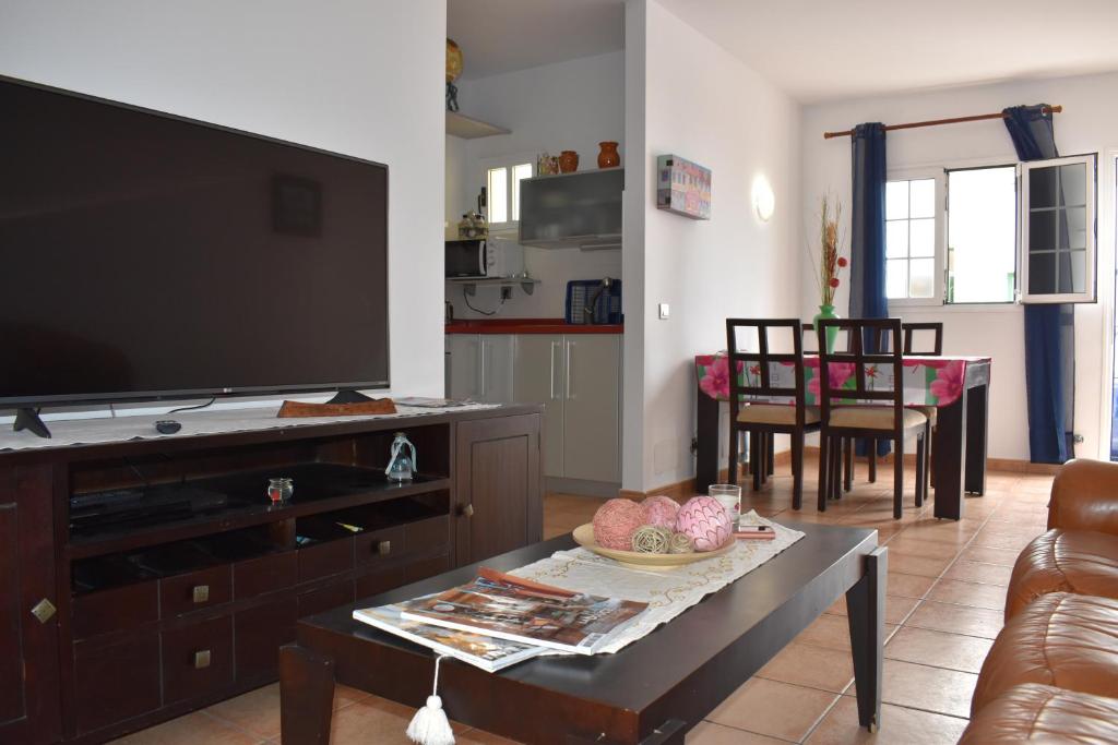 a living room with a large flat screen tv at Famara Vela in Famara