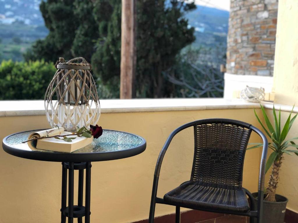 a table and a chair on a balcony at Chill out studio in the leafy Livadia village in Andros