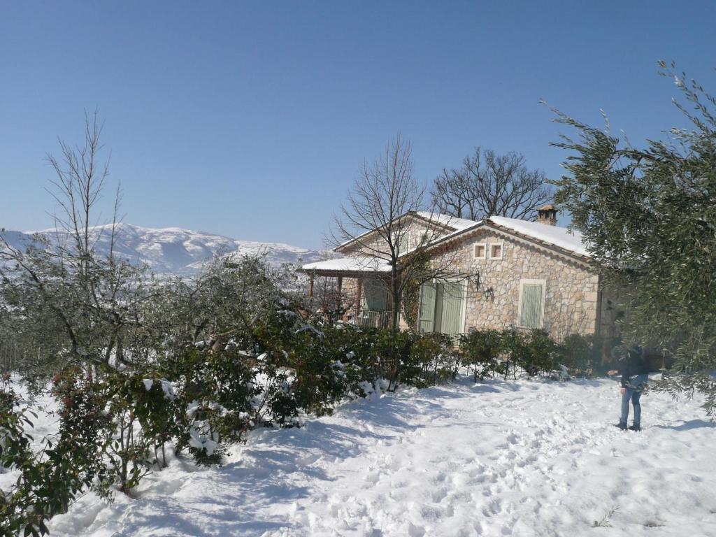 una persona parada en la nieve frente a una casa en Il Bruco appartamenti in b&b, en San Donato Val di Comino
