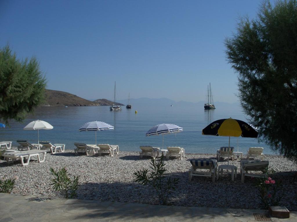 a beach with tables and chairs and umbrellas at Kleopatra's Rooms in Livadia
