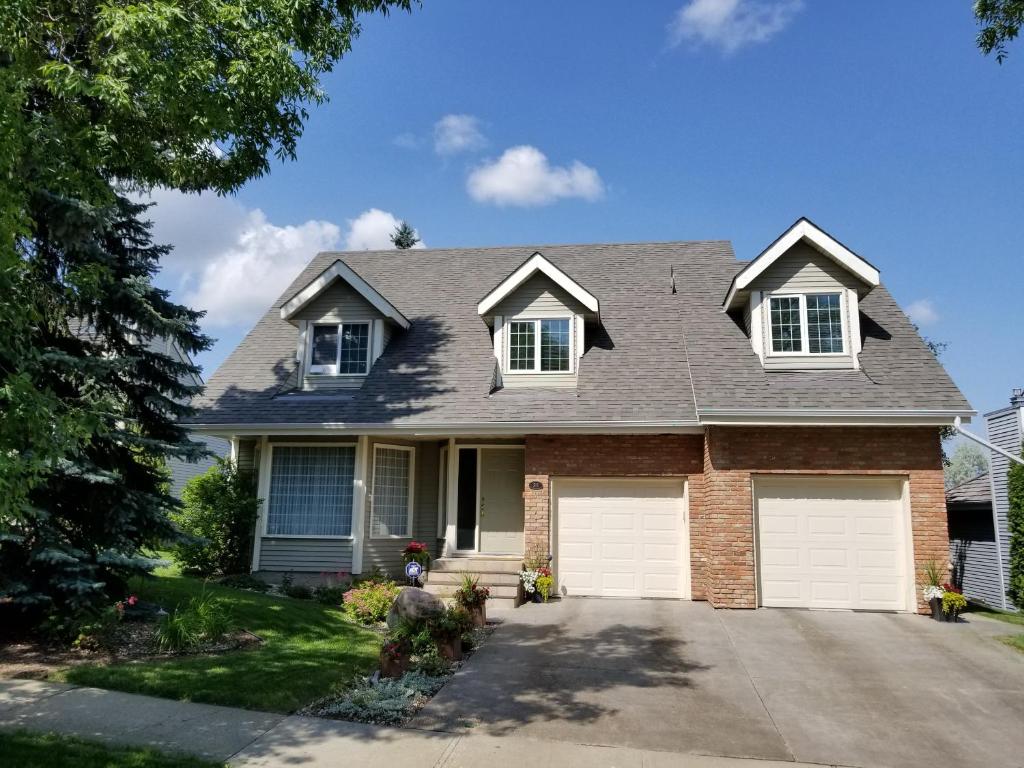 une maison avec deux portes de garage blanches dans l'établissement Window Hill, à Saint-Albert