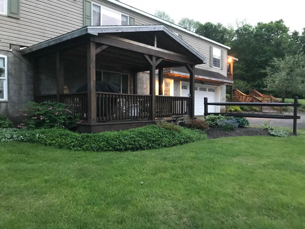 een huis met een veranda met een terras bij Coolis Apartment in Richfield Springs