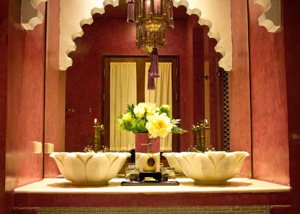 a bathroom with a mirror and flowers on a counter at Kenting Amanda Hotel in Nanwan