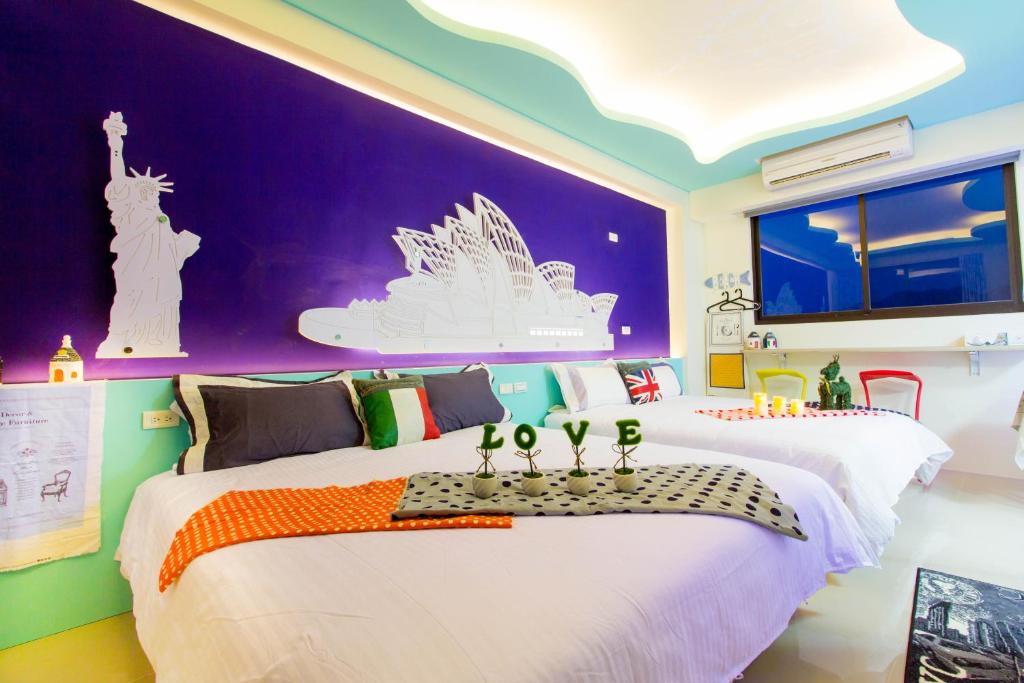 two beds in a room with purple and green walls at 宜蘭F1包棟 villa in Wujie