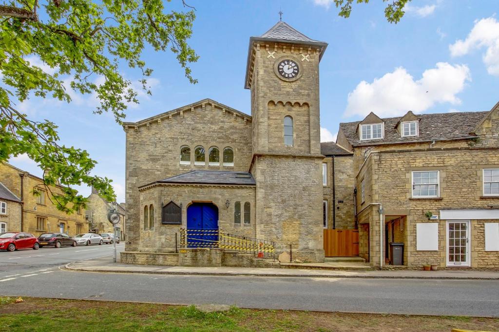an old stone building with a clock tower at Church suite, Stow-on-the-Wold, Sleeps 4, town location in Stow on the Wold