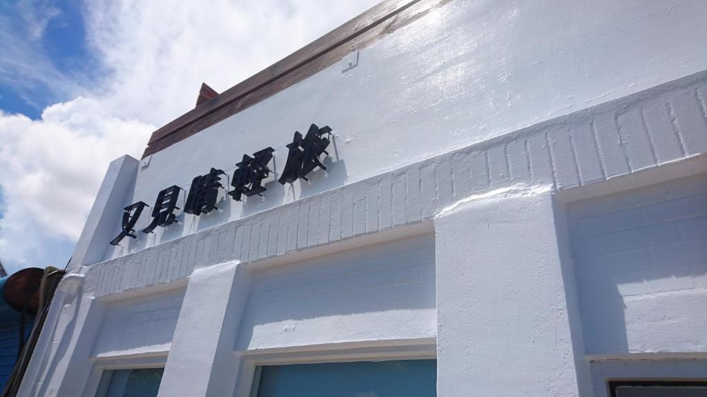 a white building with a sign on top of it at Seeing Sunshine Homestay in Nanwan