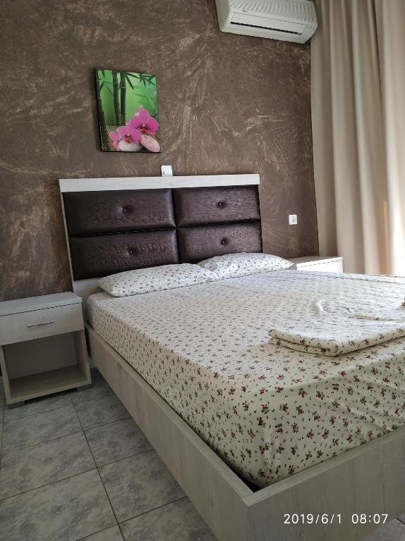 um quarto com uma cama com um bicho de peluche cor-de-rosa em LAZAROS APARTMENTS em Olympiakí Aktí