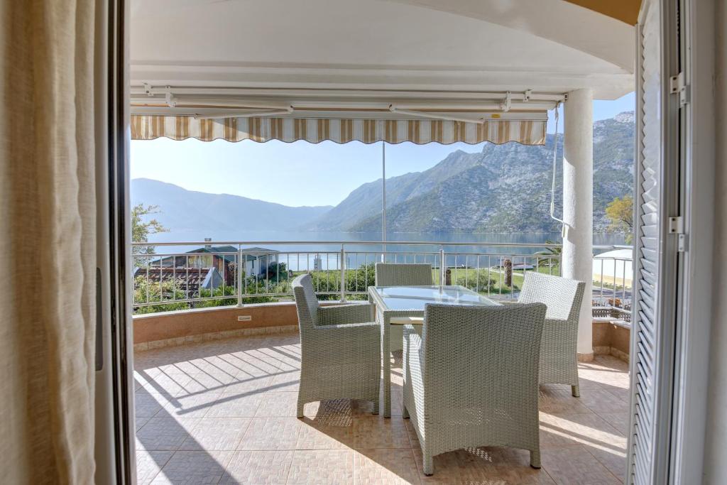 a patio with a table and chairs and a view of the mountains at Fashion Beach Apartments in Risan