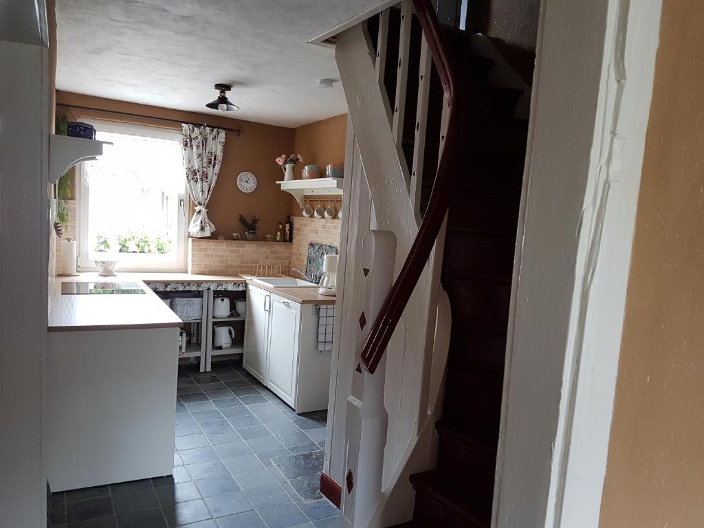 uma cozinha com uma escada que leva a uma cozinha com um lavatório em super gemütlich - DasPaterhaus em Monschau