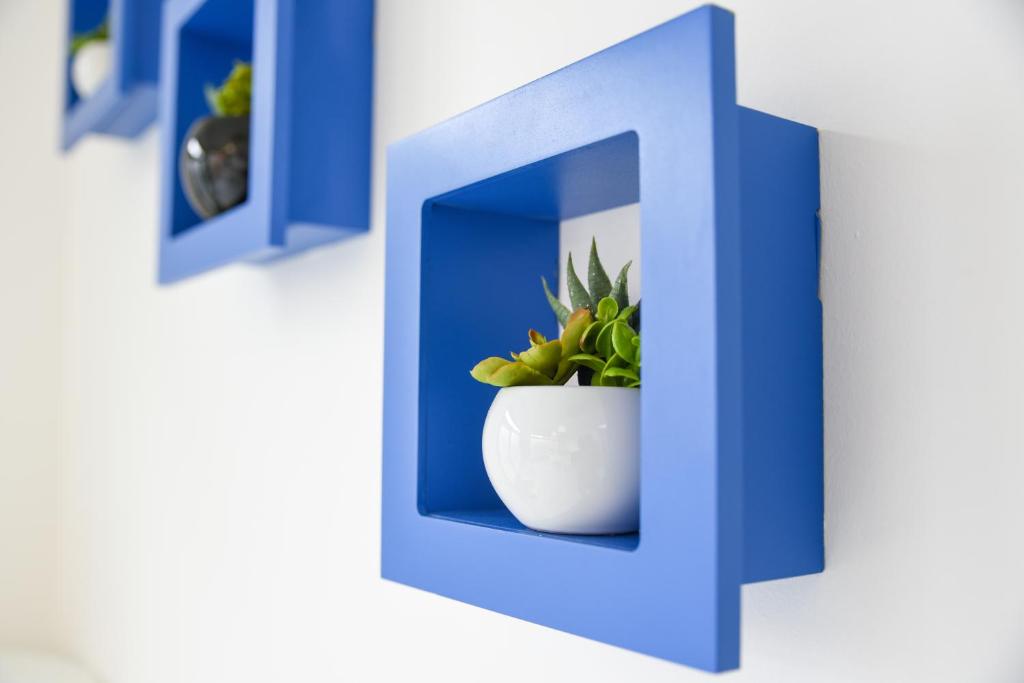 a blue letter h with a plant in a vase at Bed and Breakfast Porto Flavia in Iglesias
