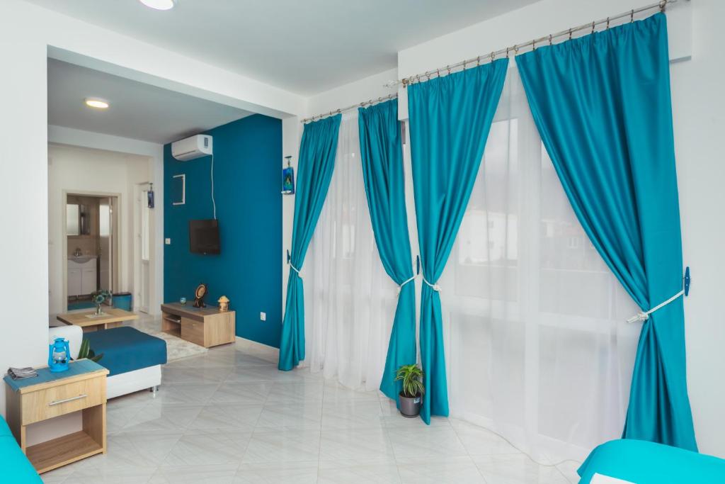 a room with blue walls and blue curtains at Apartments Suster in Bar