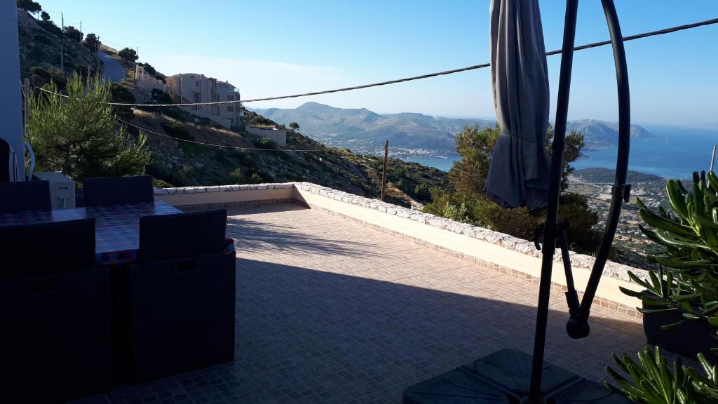 a patio with an umbrella and a view of the ocean at Viva B&B in Anavyssos