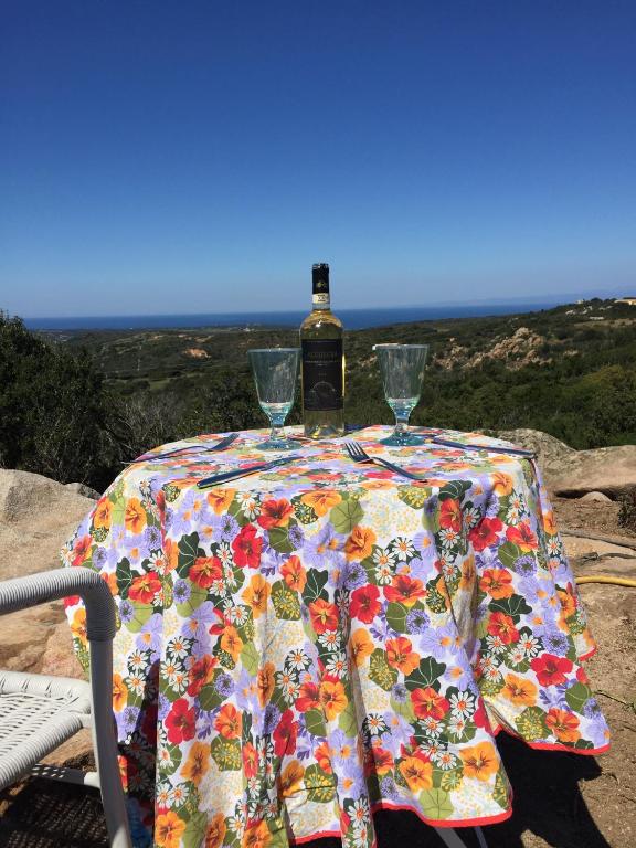 a table with a bottle of wine and two glasses at Stazzu Giasti Agriturismo in Aglientu