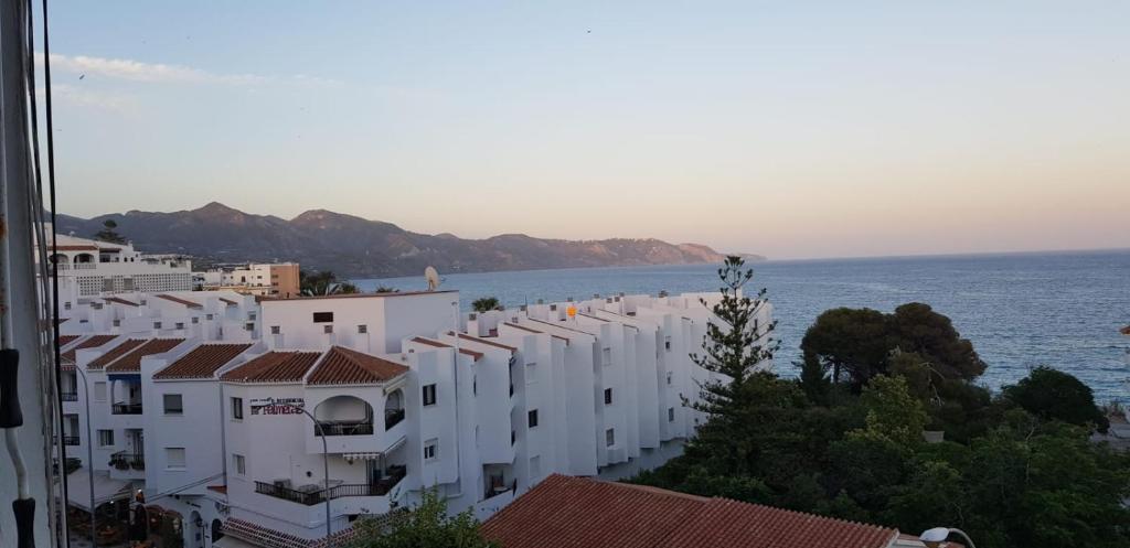 rząd białych budynków nad oceanem w obiekcie Apartment Edificio Sur 19 w mieście Nerja