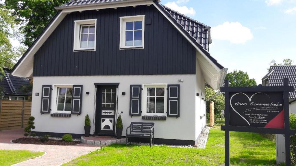 a black and white house with a sign in front of it at Haus Sommerliebe in Prerow