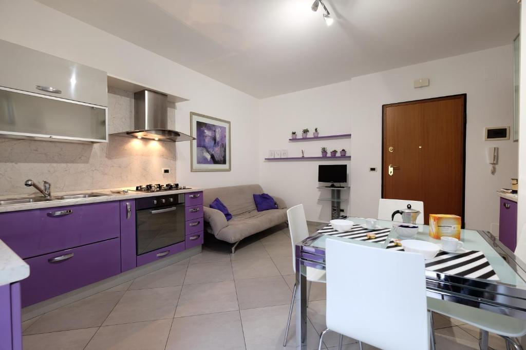 uma cozinha com armários roxos e uma sala de estar em Mango Pineto Vacanza em Pineto