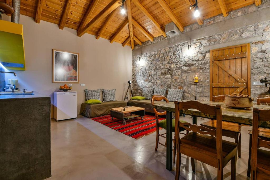kuchnia i salon z kamienną ścianą w obiekcie Boutique Stone Cottage w mieście Dhímaina