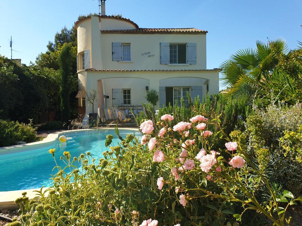 a house with a swimming pool and flowers at Bastide Philomen in Pérols