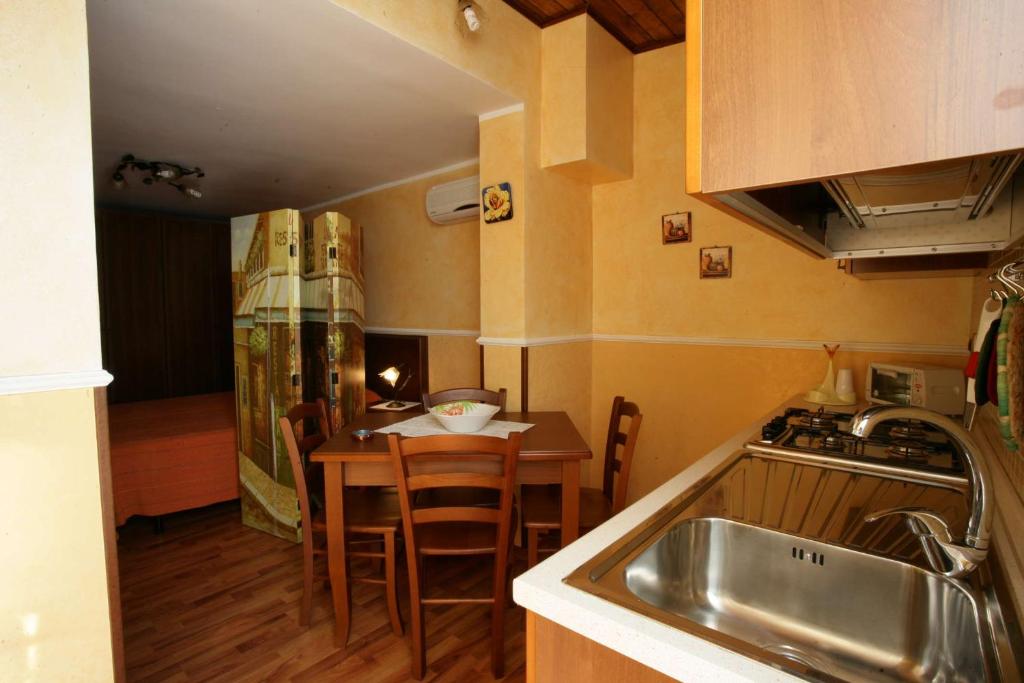 a kitchen with a sink and a table with chairs at Casa Anita in Pozzallo