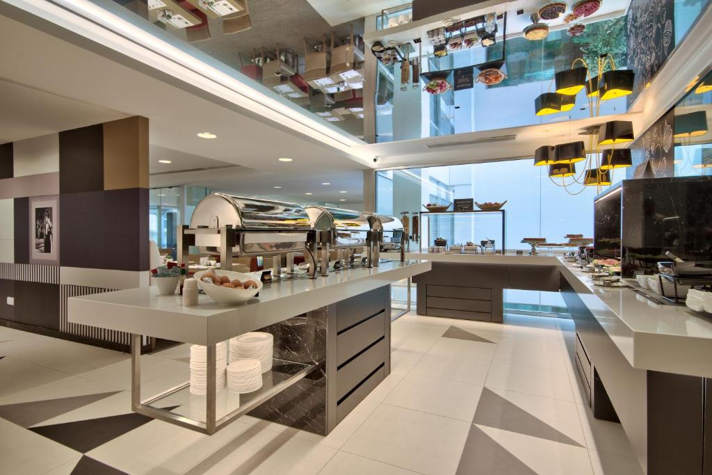 a large kitchen with a counter with dishes at Hotel Valentina in St. Julianʼs