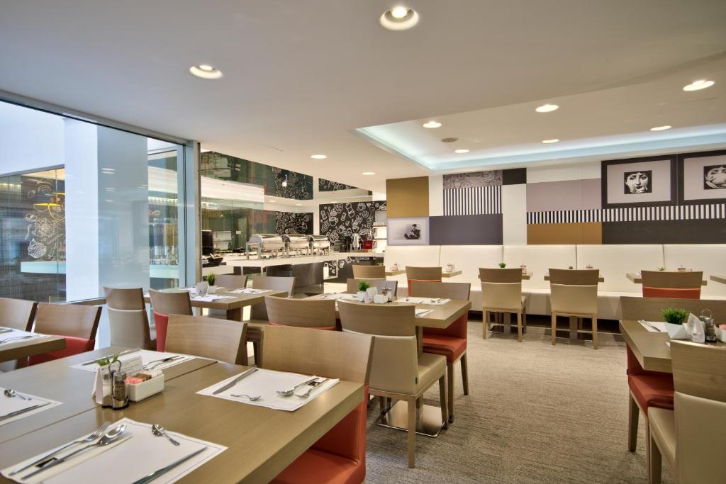 a dining room with tables and chairs in a restaurant at Hotel Valentina in St. Julianʼs