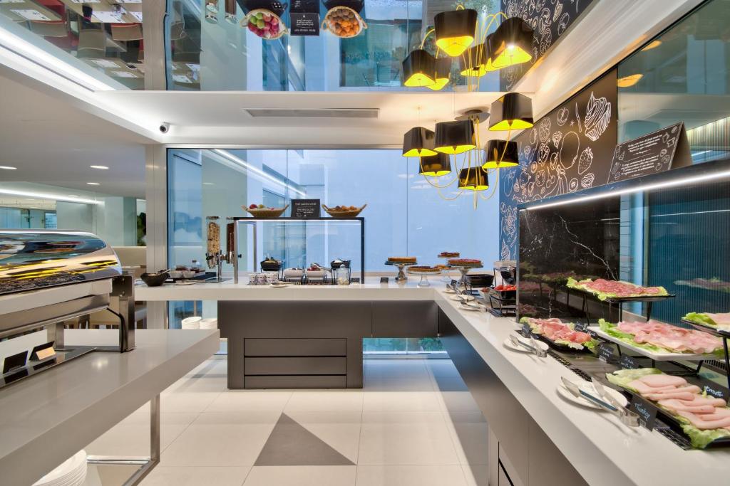 a restaurant with a counter with food on display at Hotel Valentina in St. Julianʼs