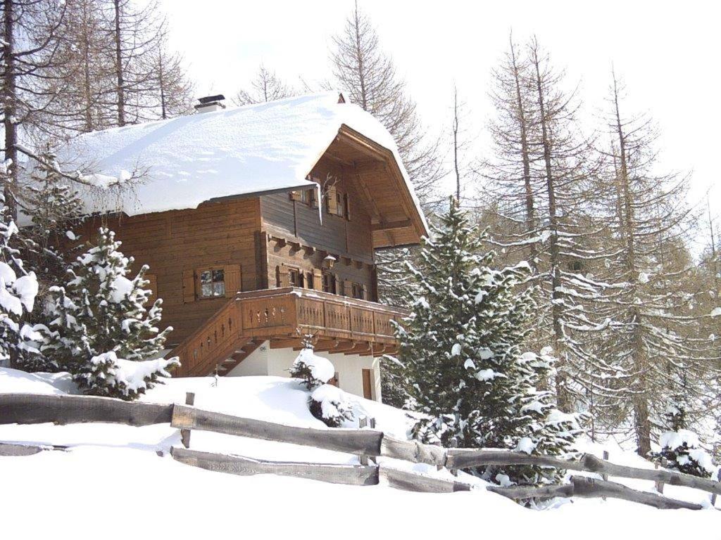 ein Blockhaus mit einem schneebedeckten Dach in der Unterkunft FELBER Hüttn in Patergassen