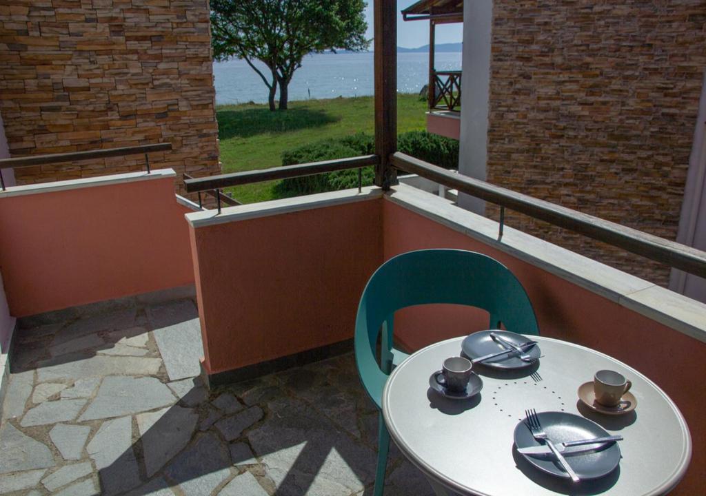 una mesa y sillas en un balcón con vistas al océano en Beachfront stylish maisonette in Ierissos en Ierissos