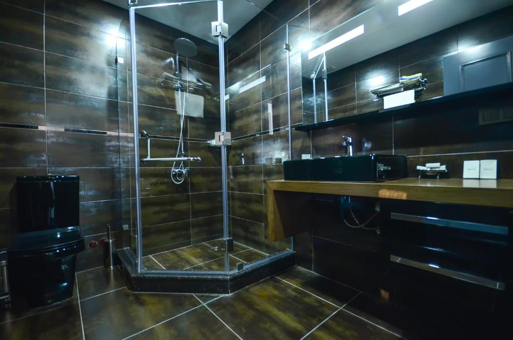 Batumi Palm Hotel في باتومي: حمام كبير مع دش ومغسلة