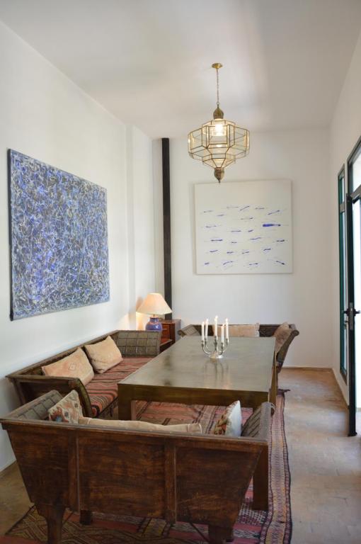 a living room with a table and a couch at RIAD OASIS D'ASILAH in Asilah