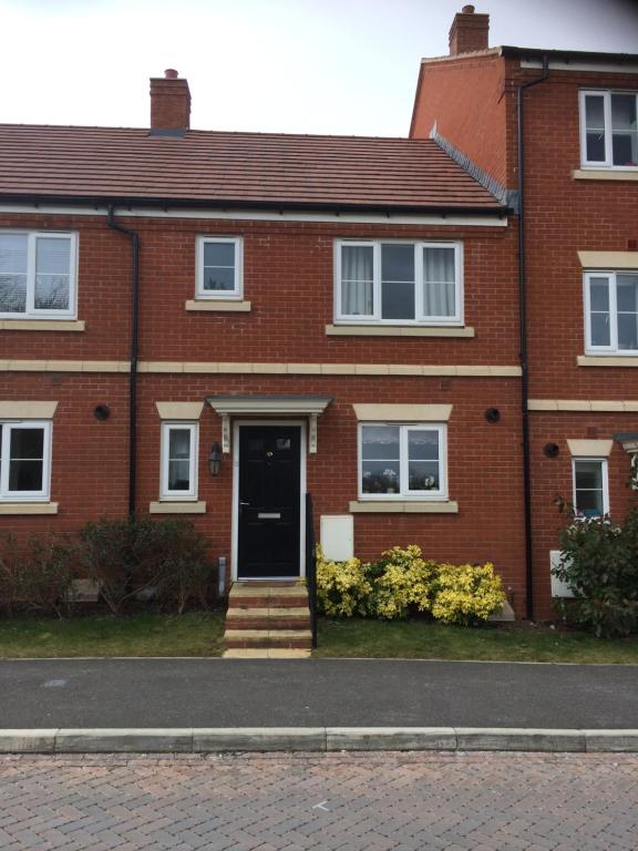 uma casa de tijolos vermelhos com uma porta preta em Cozy Room em Oxford