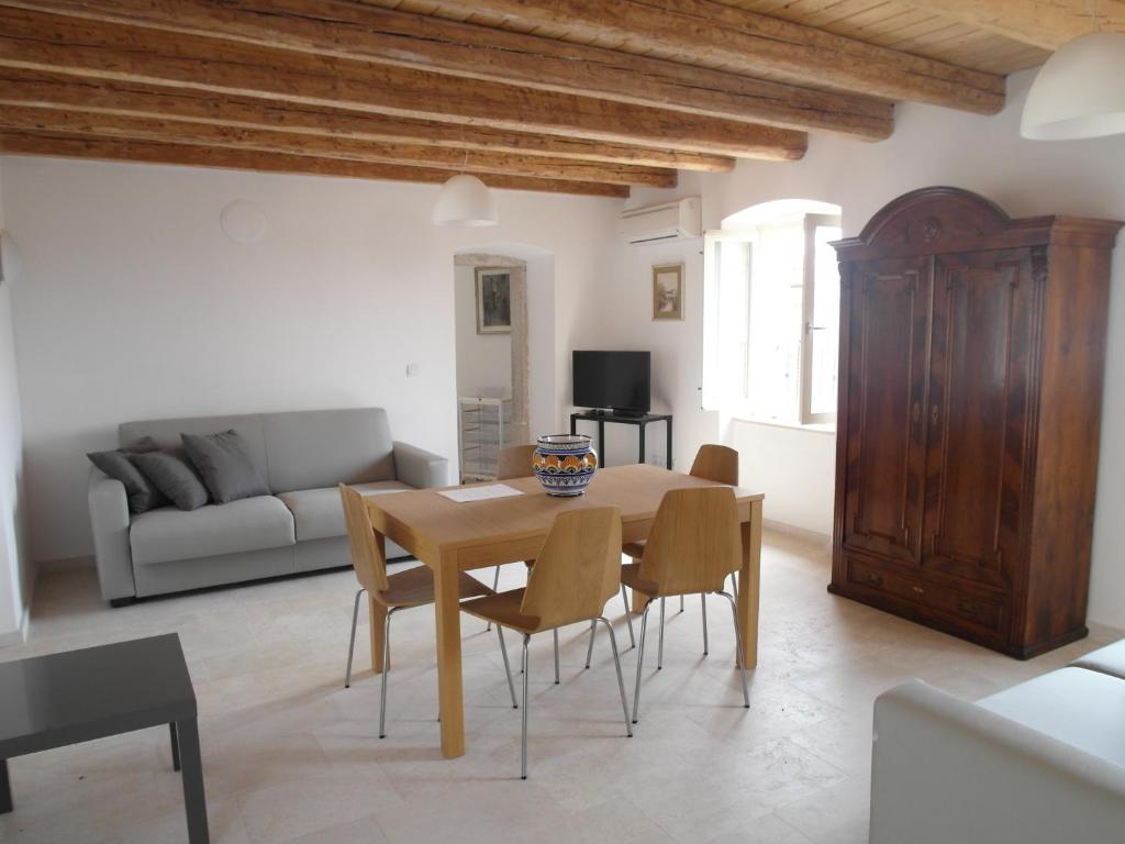 a living room with a wooden table and chairs at Apartments Antica Orsera in Vrsar