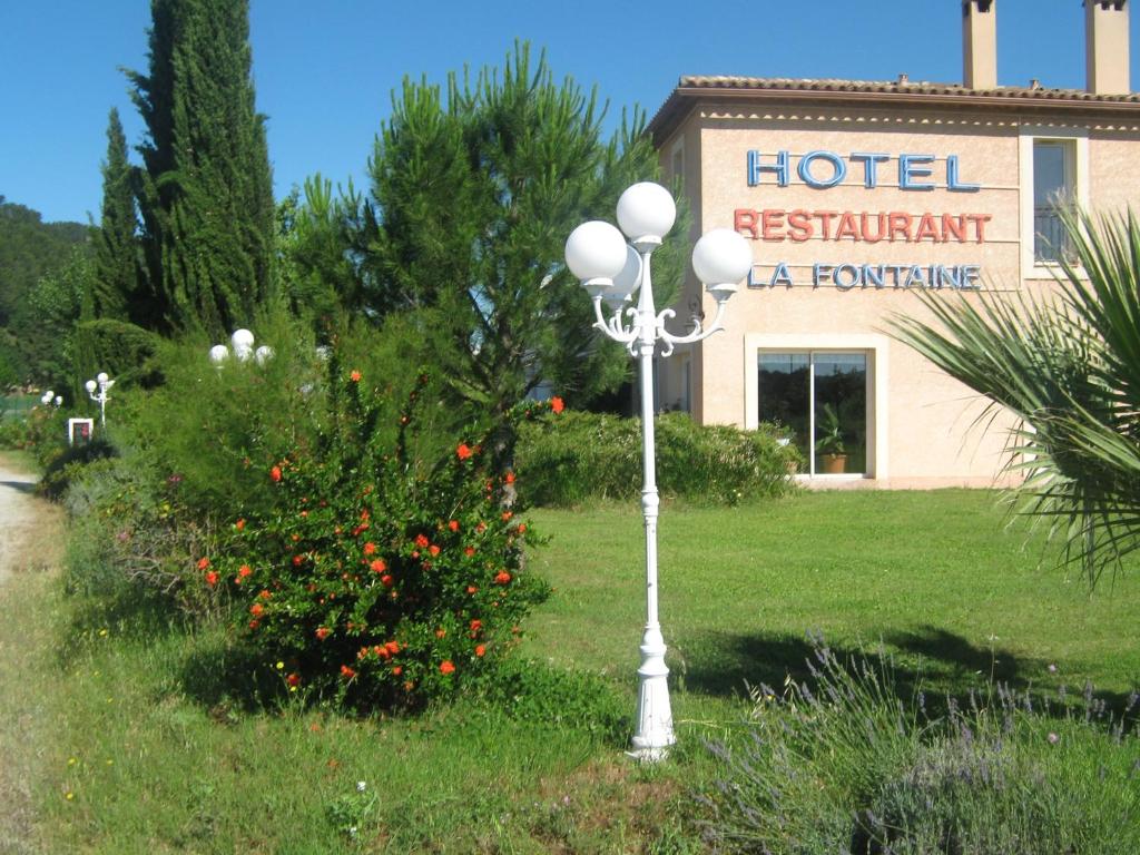 una luz de la calle en el césped frente a un edificio en La Fontaine, en Vidauban